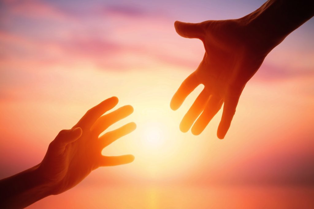 Picture of two hands with sunrise