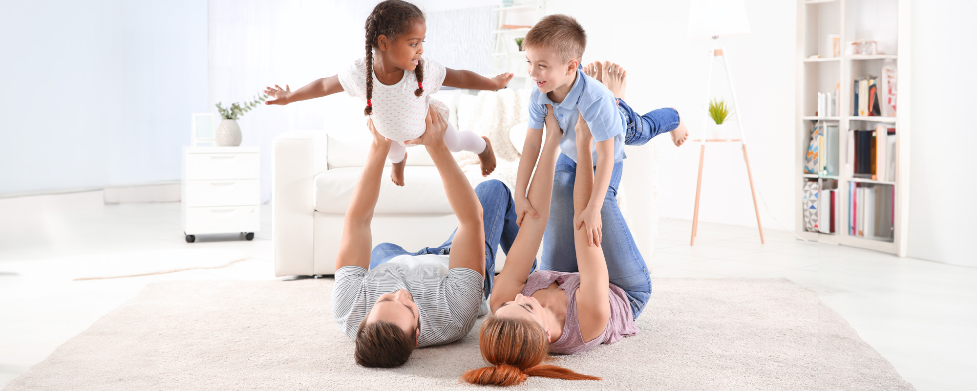 happy interracial family playing on floor