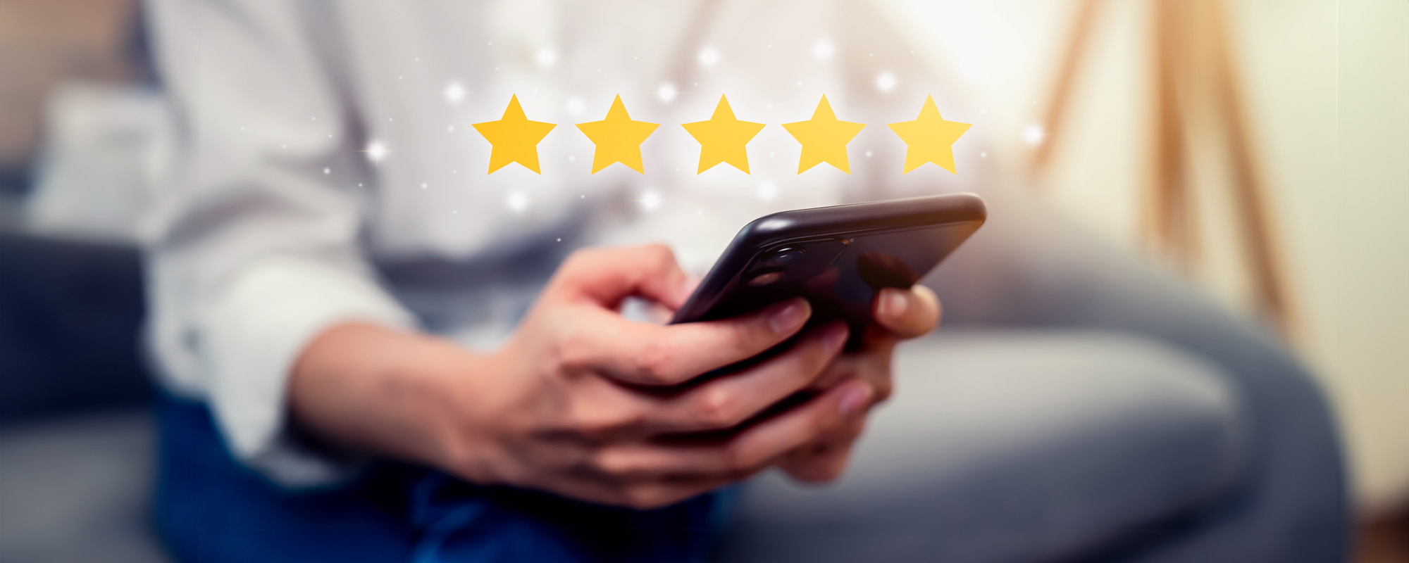 person holding phone with 5 stars above