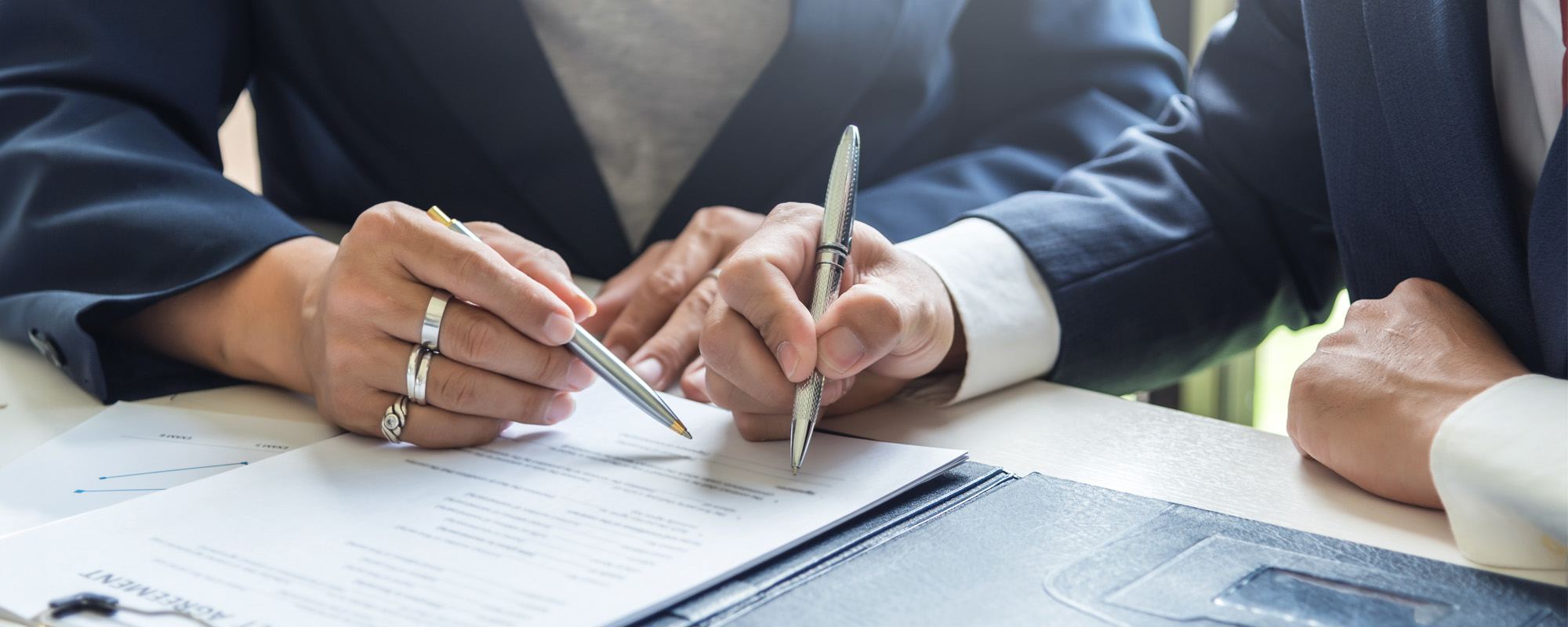 two people signing documents