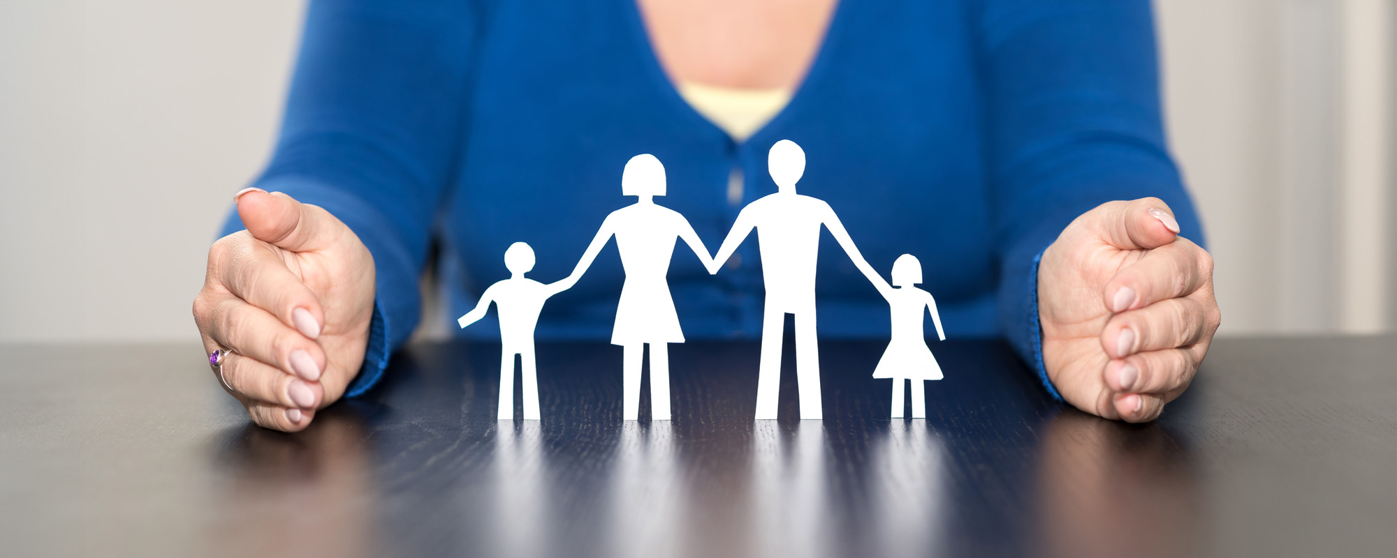 woman with hands surrounding family cutouts