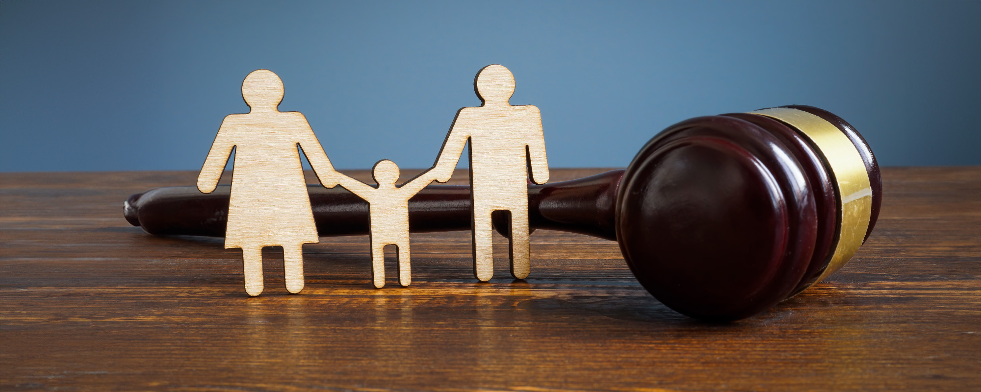 wooden cutout of family and gavel on table