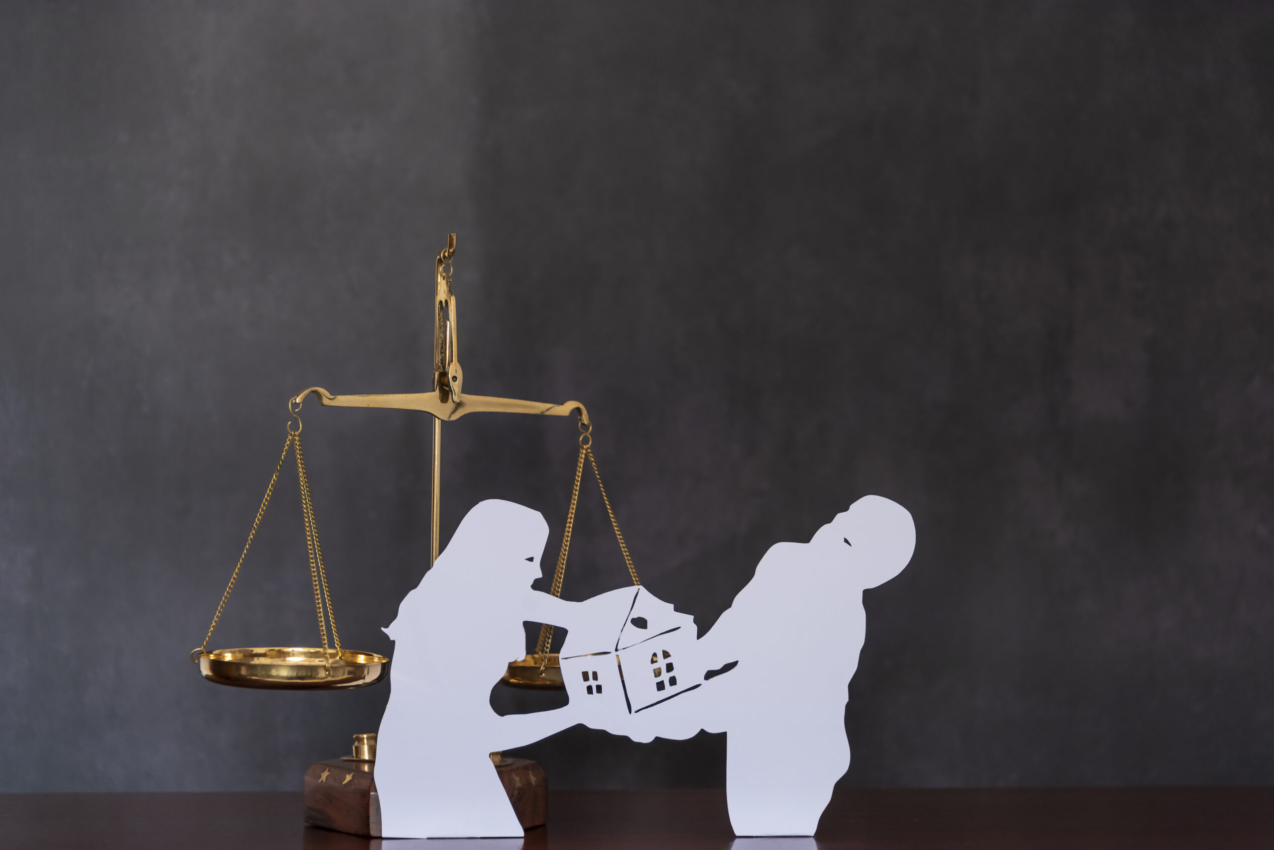 Division of property after a divorce. Paper cut out of couple fighting over property