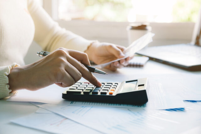 women calculate domestic bills at home. using calculator at modern office and checking balance and costs.women doing paperwork for paying taxes