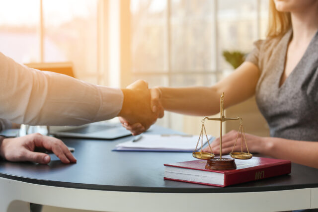 Man and lawyer shaking hands in office